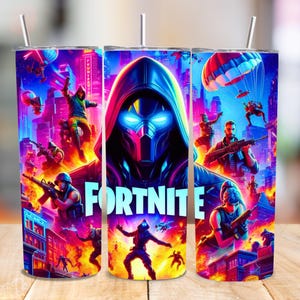Puede incluir: Un vaso de acero inoxidable con un diseño vibrante de Fortnite. La obra de arte muestra un personaje encapuchado con ojos azules brillantes, rodeado de escenas de acción del juego. La palabra "FORTNITE" se muestra en blanco.
