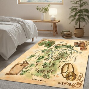 May include: A rectangular area rug featuring a detailed map design with green, brown, and beige tones. The map includes text and illustrations of a ring and scroll. The rug is placed on a gray carpet in a bedroom setting.