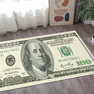 以下が含まれることがあります： 100米ドルの紙幣に似せて印刷された長方形のラグ。ベンジャミン・フランクリンの肖像画、「ONE HUNDRED DOLLARS」の文字、および通貨のその他の詳細が特徴です。ラグはクリーム色、緑色、黒色です。