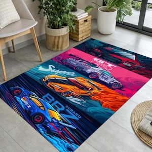 May include: A rectangular rug featuring stylized illustrations of four sports cars in vibrant colors. The cars are labeled "BRZ Subaru", "Supra", and "GT R". The rug has a colorful, dynamic design.