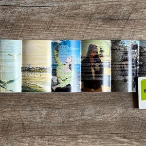 May include: A cassette tape with a lime green label and white casing sits next to a folded booklet. The booklet features various images and text, including photos of people and landscapes. The cassette label reads "Lana Del Rey, Norman Fucking Rockwell".