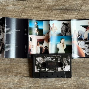 May include: A black cassette tape and album art from Lana Del Rey's "Chemtrails Over the Country Club" album. The album art features a collage of photos and the cassette tape has the album title and artist's name.