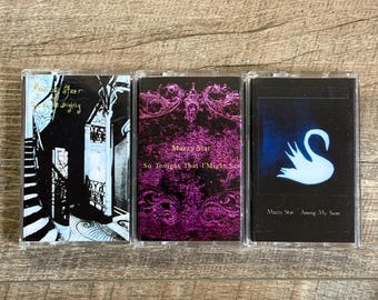 May include: Three cassette tapes with album artwork. The first features a black and white staircase design. The second has a purple background with text. The third has a black background with a white swan.