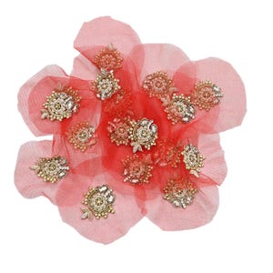 May include: A cluster of decorative floral embellishments. Each piece features a central design of sparkling crystals and beads, surrounded by a gold-toned frame. They are arranged on a sheer, red fabric, creating a layered effect. Ideal for craft projects.