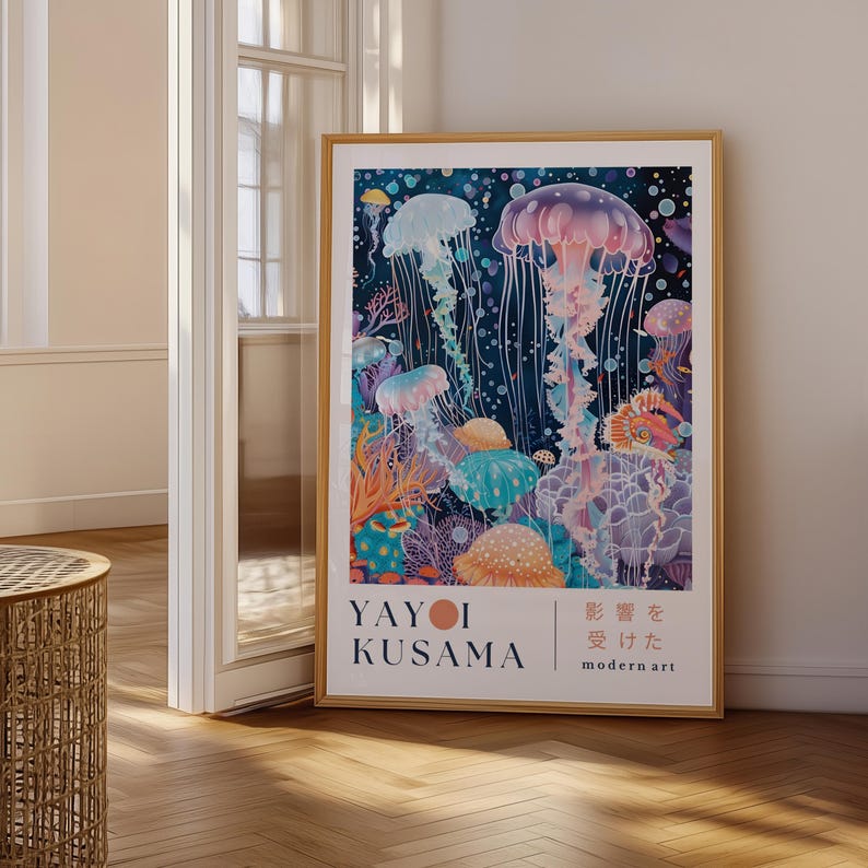 Puede incluir: Una impresi&oacute;n art&iacute;stica enmarcada con una ilustraci&oacute;n de acuarela de medusas en tonos azules, morados y naranjas. La obra de arte incluye el texto "YAYOI KUSAMA" y texto japon&eacute;s. La impresi&oacute;n se exhibe en una habitaci&oacute;n con piso de madera.