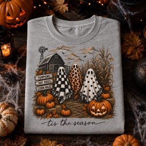 Puede incluir: Una sudadera gris jaspeado con un gráfico de tres fantasmas frente a un granero y un campo de maíz. Los fantasmas tienen patrones de cuadros, leopardo y lunares. El texto dice PUMPKINS, HAY RIDES, CORN MAZE y tis the season.