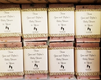 May include: Several bars of pink and brown soap are wrapped with a cream-colored label and natural twine. The label reads "From Gina and Dylan's Baby Shower to Yours" with a footprint graphic and the date 9/28/18.