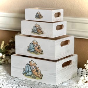 May include: Set of four white wooden storage boxes with Winnie the Pooh and Piglet illustrations. The boxes are stacked on top of each other and have handles on the sides.