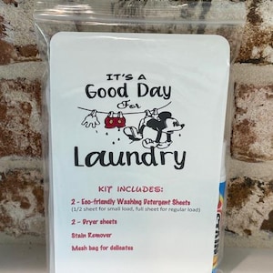 May include: A clear plastic bag containing a laundry kit. The kit includes eco-friendly washing detergent sheets, dryer sheets, stain remover, and a mesh bag. The front of the kit has the text "IT'S A Good Day For Laundry" with a cartoon illustration.