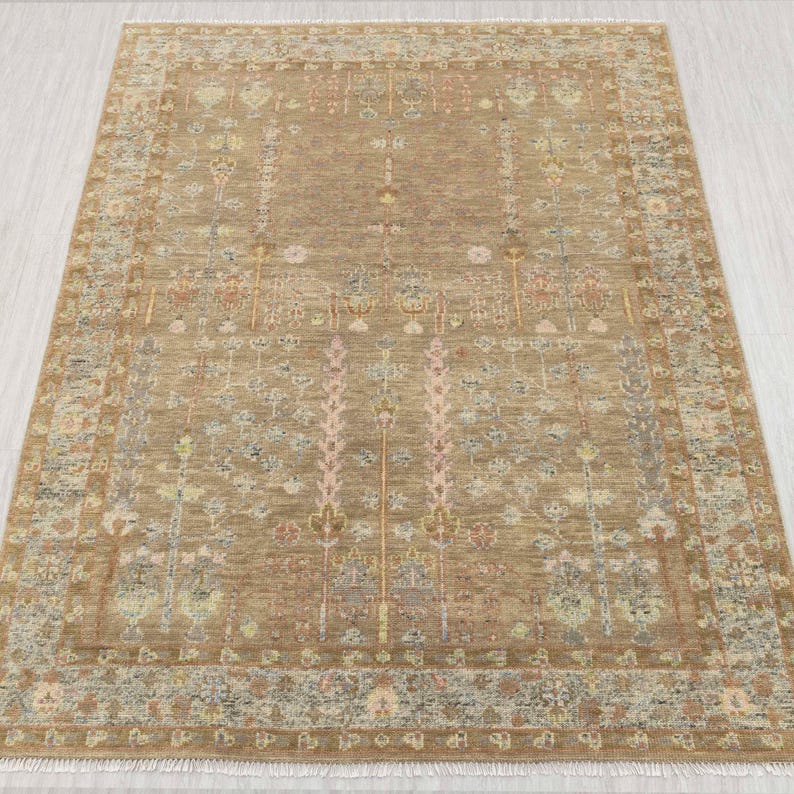 May include: A rectangular beige rug with a detailed floral design. The rug has a central field with vertical floral patterns and a decorative border. The color scheme includes beige, pink, blue, and yellow, creating a warm and inviting look. The rug is suitable for a living room.