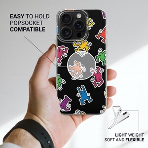 May include: Clear phone case with a black background and colorful dancing figures. The case is labeled "EASY TO HOLD POPSOCKET COMPATIBLE" and "LIGHT WEIGHT SOFT AND FLEXIBLE".