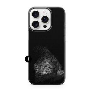 May include: Black iPhone case featuring a black and white image of a leopard. The leopard is lying down, with its head and eyes visible. The case has a black background and a clear border.