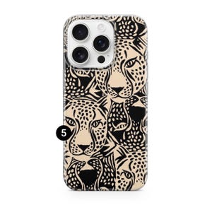 May include: A phone case featuring a repeating pattern of cheetah faces in black and tan. The case has a clear border and a camera cutout. The number 5 is printed in black on the bottom left corner of the case.