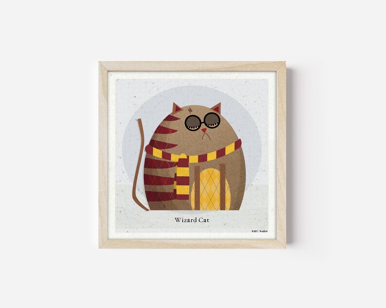 Op de afbeelding: Een ingelijste illustratie van een bruine kat met ronde bril en een rood-gele sjaal. De kat zit op een geel-wit gepatroneerd oppervlak. De tekst "Wizard Cat" staat onder de kat.