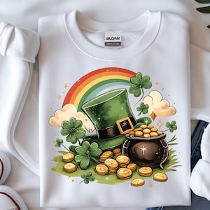 Op de afbeelding: Witte sweatshirt met een St. Patrick's Day-ontwerp. De afbeelding bevat een groene kabouterhoed, een pot met goud, een regenboog, klavers en gouden munten. Het ontwerp is gedrukt op een wit Gildan Heavy Cotton sweatshirt.