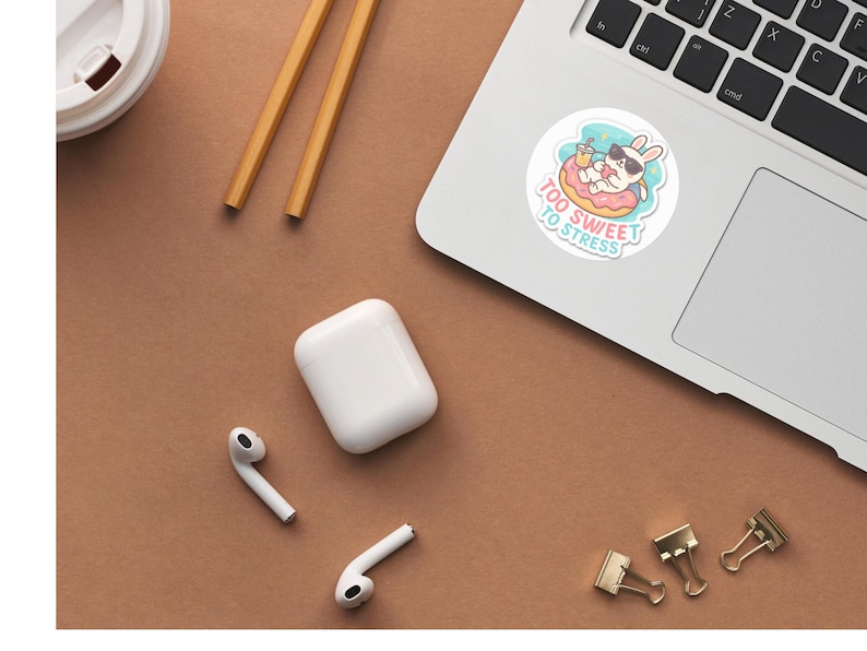 Op de afbeelding: Een ronde sticker met een witte konijn met een zwarte zonnebril, ontspannend in een roze donut-zwemband terwijl het een geel drankje vasthoudt. De tekst "TOO SWEET TO STRESS" staat in lichtblauw onder het konijn op een lichtblauwe achtergrond.