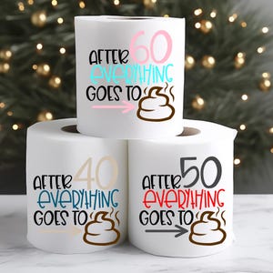 May include: Three white toilet paper rolls with humorous text. The top roll reads "After 60 Everything Goes To" with a poop emoji. The other rolls say "40" and "50" with similar text and emojis. The text is in various colors.