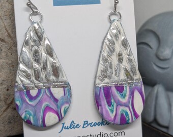 Pendientes bohemios en forma de lágrima color magenta y plata.
