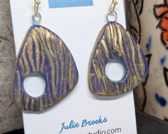Pendientes colgantes de oro y azul con diseño de agua costera.
