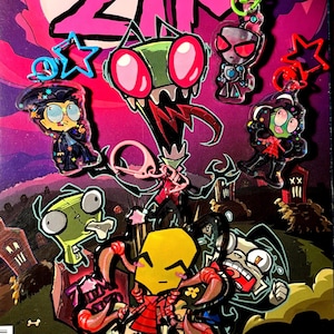 Może przedstawiać: Okładka komiksu Invader Zim z kilkoma brelokami z postaciami. Breloki przedstawiają postacie takie jak Zim, Dib i Gaz. Tło to fioletowo-różowa kolorystyka z tytułem "Invader Zim" u góry. Breloki są przymocowane do kolorowych klipsów w kształcie gwiazd.