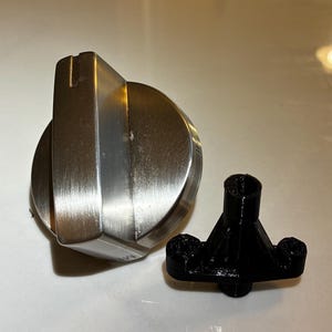 May include: A white ceramic mug with a black handle and the text "But First, Coffee" in a bold, black font. The mug is set against a blurred background, suggesting a cozy setting.