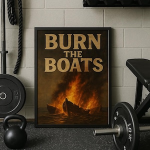 May include: Framed artwork with the text "BURN THE BOATS" above a depiction of burning ships. The image is set in a gym with weights, a kettlebell, and a weight bench. The background is a brick wall.