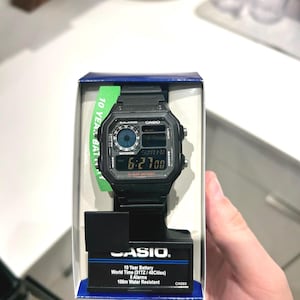 May include: A black Casio digital watch in its original packaging. The watch face displays the time and date. The packaging includes the text "10 Year Battery", "World Time", and "100m Water Resistant".
