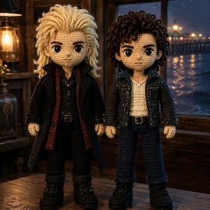 May include: Two handmade crochet dolls standing side by side. The left doll has long blonde hair, a black trench coat with a dark red inner lining, and black boots. The right doll has short dark curly hair, a dark denim jacket, a white shirt, and blue jeans.