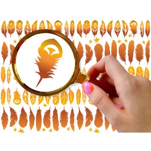 May include: A magnifying glass with a gold frame is held in a hand, focusing on a single golden feather with a gradient of orange and brown colors. The background is a white surface with a pattern of smaller golden feathers.