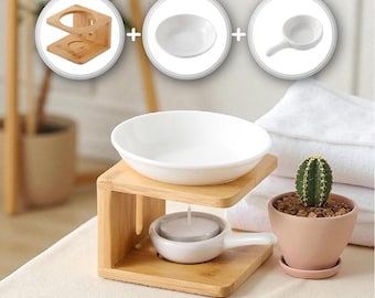 May include: A bamboo essential oil diffuser with a white ceramic bowl and a small white ceramic dish with a handle. A small cactus in a pink pot sits nearby. The diffuser is designed to hold a candle.
