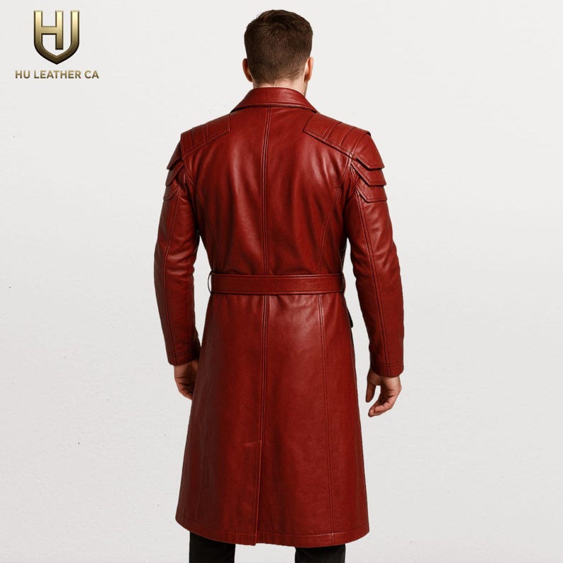 K&ouml;nnte beinhalten: Ein langer, weinroter Ledermantel mit G&uuml;rtel, von hinten gesehen. Der Mantel hat Schulterdetails und ein klassisches Trenchcoat-Design. Das Logo "HU LEATHER CA" ist oben links sichtbar.