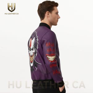 May include: Purple leather bomber jacket featuring a Joker graphic on the back and the word "HAHA" in red. The jacket has a black collar and cuffs. The HU LEATHER CA logo is visible.