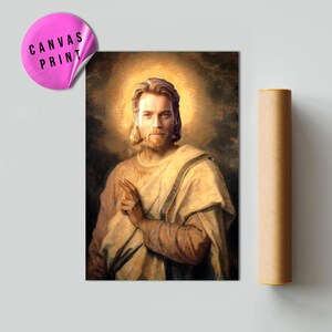 May include: A canvas print featuring a portrait of a man with long hair and a beard, surrounded by a golden halo. The man is wearing a cream-colored robe and pointing with his right hand. A pink sticker with the words "CANVAS PRINT" is in the upper left corner.