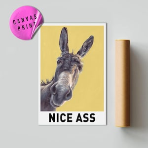 May include: A canvas print featuring a donkey with a yellow background. The donkey is looking directly at the viewer. The print has the words "NICE ASS" at the bottom. A pink sticker that says "CANVAS PRINT" is in the upper left corner.