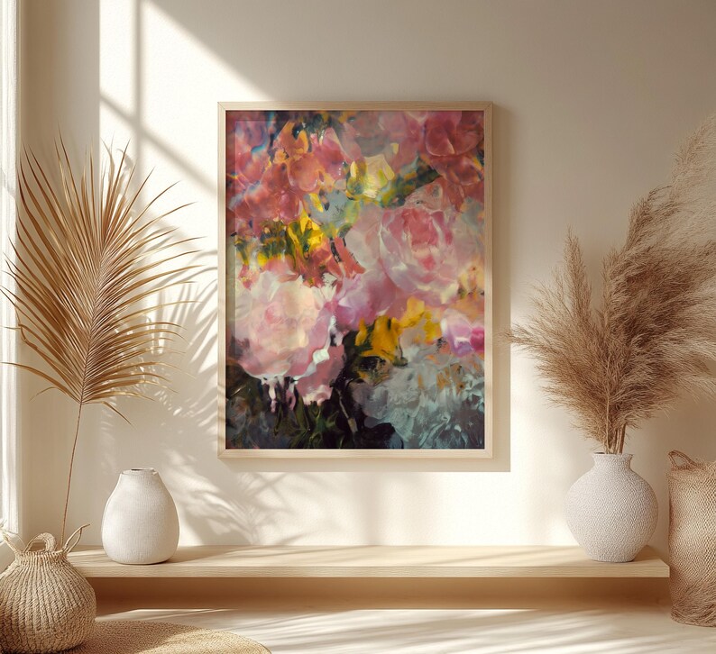 May include: An abstract floral painting in a wooden frame. The artwork features a vibrant mix of pink, yellow, and green brushstrokes, creating a textured and colorful display. The painting is a close-up of a bouquet of flowers.