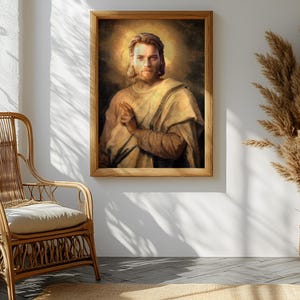 May include: A framed portrait of a man with a halo, in a light-colored robe, hangs on a white wall. A wicker chair with a cream-colored cushion sits to the left. A large arrangement of dried plants in a woven basket is to the right.
