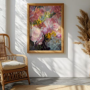 May include: A framed floral painting with pink, yellow, and white flowers hangs on a white wall. A natural wicker chair with a cream cushion sits in front of a window. Dried plants in a woven basket add to the room's decor.