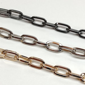 Peut inclure: Trois chaînes de différentes couleurs : or, argent et noir. Les chaînes sont composées de maillons ovales.