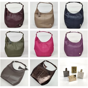 May include: A collection of hobo-style shoulder bags in various colors including burgundy, beige, navy, olive green, hot pink, purple, and metallic brown, each featuring a single handle, a side tassel, and a small rectangular logo plaque.
