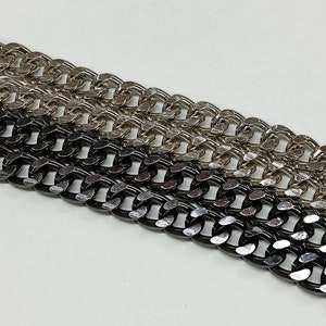 Peut inclure: Trois cha&icirc;nes m&eacute;talliques dans diff&eacute;rentes finitions&nbsp;: noir, argent et or. Les cha&icirc;nes sont toutes du m&ecirc;me style, avec un design &agrave; maillons plats.