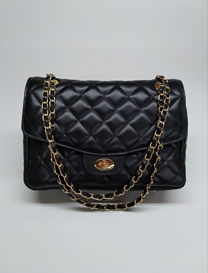 black leather and gold hardware, oval front clasp. large size, elegant quilted large purse.