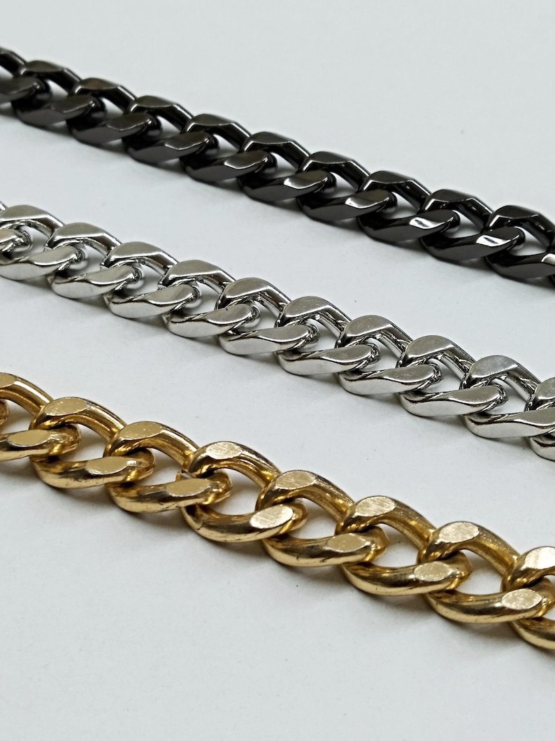 Puede incluir: Tres cadenas, una dorada, una plateada y una negra, se colocan sobre una superficie blanca. Las cadenas son todas del mismo estilo, con un dise&ntilde;o de eslab&oacute;n de cadena.
