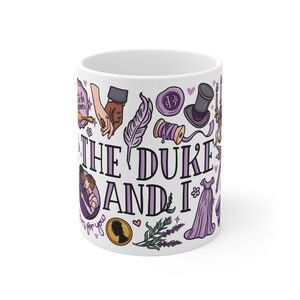 Peut inclure: Tasse en c&eacute;ramique blanche avec un motif comprenant des illustrations et du texte de "The Duke and I". Le motif comprend une plume, un haut-de-forme, une robe et le texte "The Duke and I" en violet.