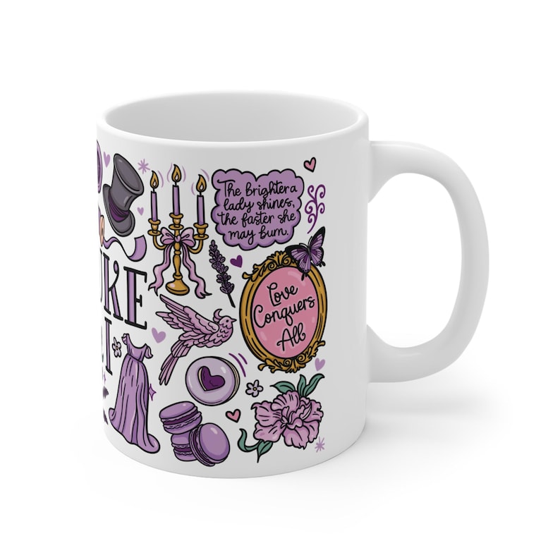 Peut inclure: Mug en c&eacute;ramique blanche avec un motif int&eacute;gral orn&eacute; d'illustrations violettes et dor&eacute;es. Le motif comprend un chapeau haut de forme, une robe, un oiseau, un chandelier et le texte "Love Conquers All".