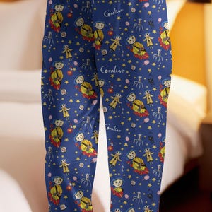 Peut inclure: Pantalon de pyjama bleu avec un motif r&eacute;p&eacute;t&eacute; avec le mot "Coraline", des &eacute;toiles et des illustrations de personnages du film. Le pantalon de pyjama a une taille &agrave; cordon et une coupe d&eacute;contract&eacute;e.
