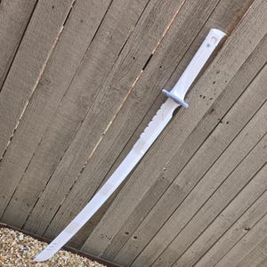 May include: A white katana sword with a straight blade and a curved tip. The handle is white with a light blue guard. The sword is set against a weathered wooden fence.