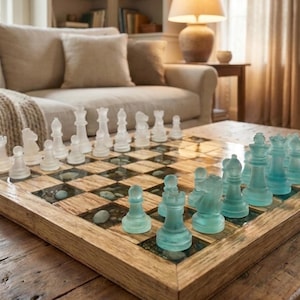May include: A decorative chess set with a wooden board and clear and blue glass pieces. The board has a natural wood frame and squares with embedded stones. The chess pieces are arranged on the board, ready for play.