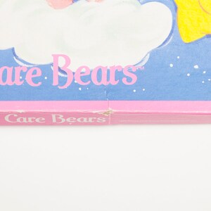 Może przedstawiać: R&oacute;żowy i niebieski kalendarz Care Bears z tekstem "Care Bears" i "20" na przodzie.