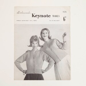 May include: Vintage black and white advertisement for Keynote Wools. The image features two women wearing light-coloured cardigans. The text on the advertisement reads "Keynote Wools" and "6". The bust size is listed as 91-102 cm.