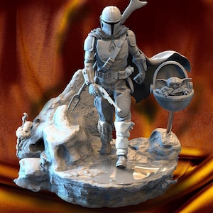 Puede incluir: Una figura gris del Mandaloriano, personaje de la serie Star Wars, caminando sobre una superficie rocosa. La figura está armada y lleva un arma. A la derecha, una pequeña cápsula flotante con Grogu.
